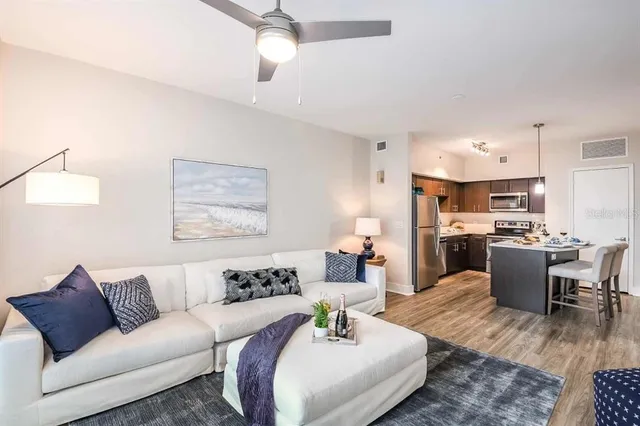 a living room with furniture kitchen view and a chandelier