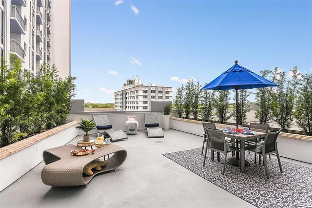 a view of a patio with couches table and chairs potted plants and palm trees
