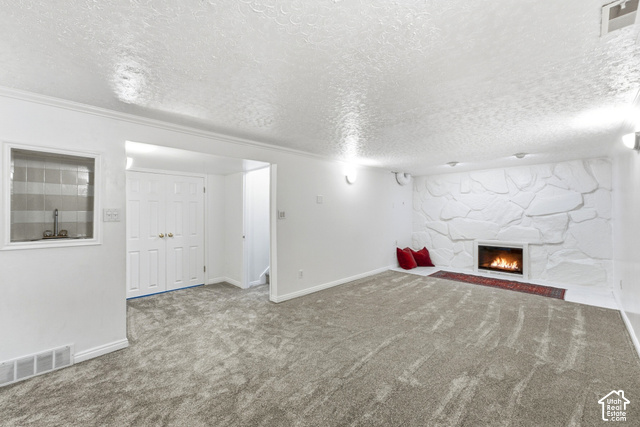 8746 Gladiator Way Sandy, UT 84094 - Photo 21 of 36 Expansive carpeted area featuring a stone fireplace with hearth, built-in shelving, and bifold doors