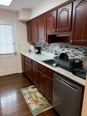 a kitchen with granite countertop stainless steel appliances a sink dishwasher refrigerator stove and cabinets