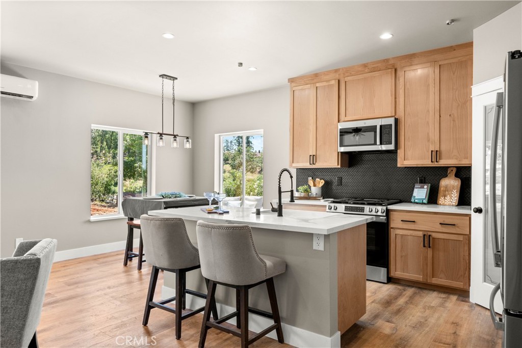 5334 Filbert Street Paradise, CA 95969 - Photo 6 of 30 a kitchen with stainless steel appliances granite countertop a stove a sink a microwave a refrigerator and white cabinets with wooden floor