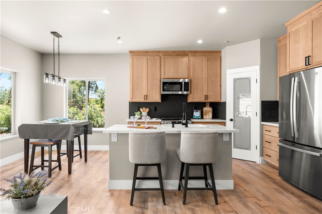 5334 Filbert Street Paradise, CA 95969 - Photo 7 of 30 a kitchen with stainless steel appliances a dining table chairs refrigerator microwave and cabinets