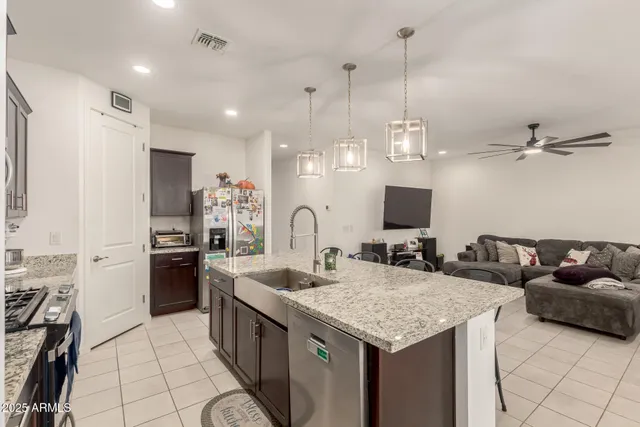 a kitchen with stainless steel appliances granite countertop a sink and a refrigerator
