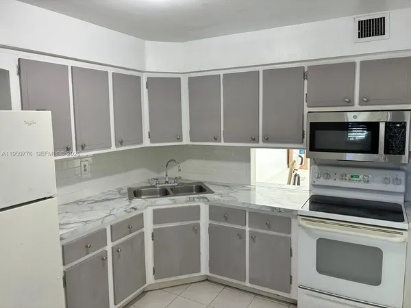 a kitchen with a sink stove and microwave