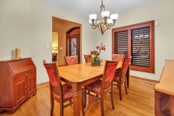 a dining room with furniture a chandelier and wooden floor