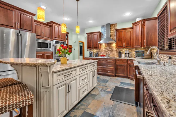 a kitchen with stainless steel appliances granite countertop a sink a stove and a refrigerator