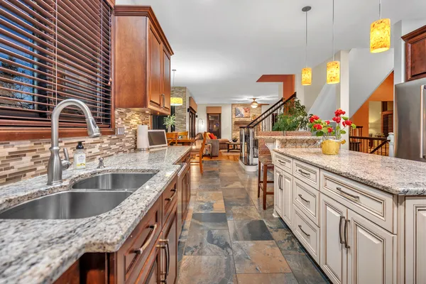 a kitchen with stainless steel appliances granite countertop a sink and a wooden cabinets