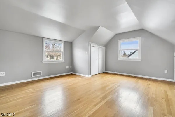 an empty room with windows and closet