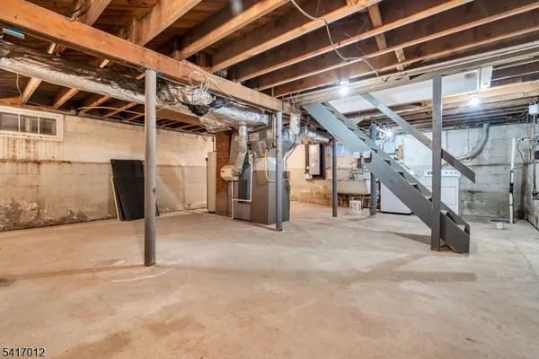 a view of an empty room with wooden stairs