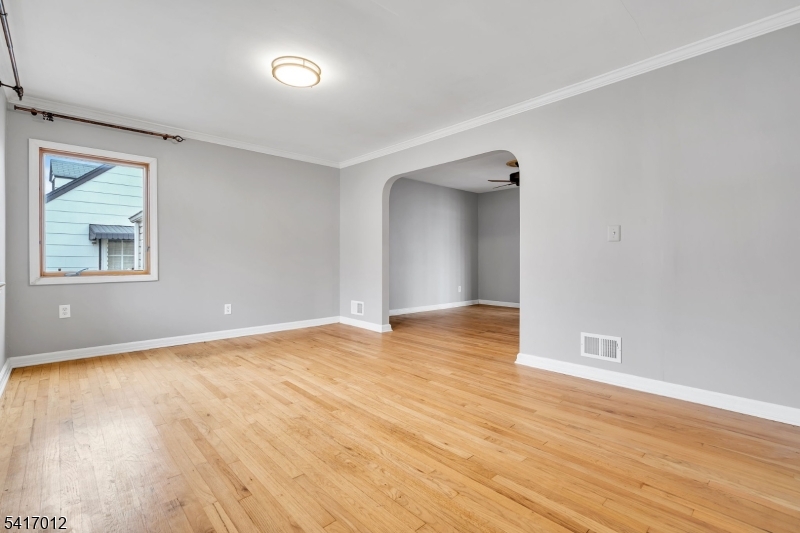 823 Pinewood Road Union, NJ 07083 - Photo 4 of 28 a view of an empty room with wooden floor and a window