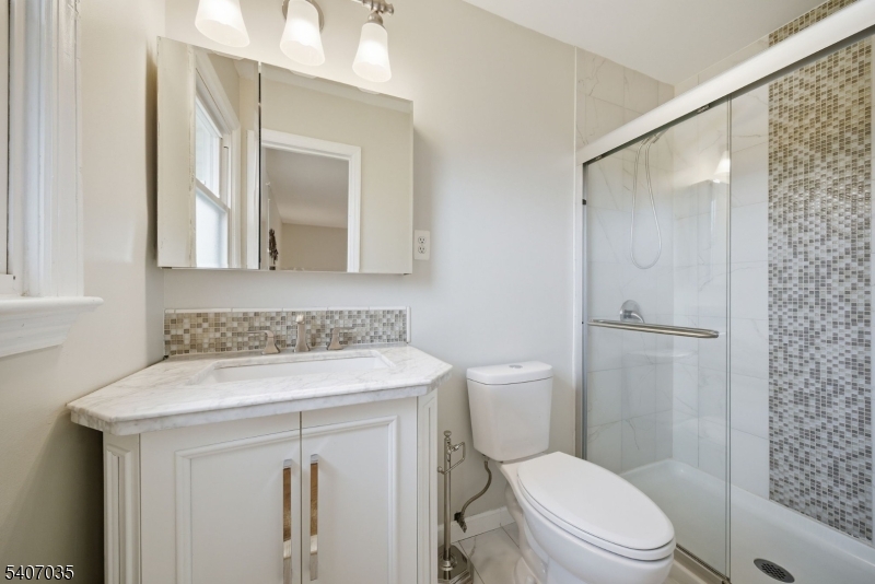 11 Deerfield Road Parsippany, NJ 07054 - Photo 23 of 42 a bathroom with a sink a toilet a mirror and shower