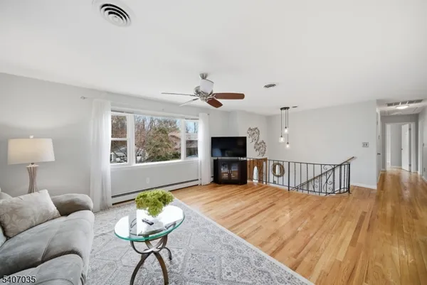 a view of a dining room with furniture a chandelier and wooden floor