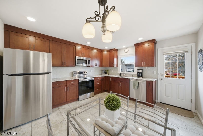 11 Deerfield Road Parsippany, NJ 07054 - Photo 10 of 42 a kitchen with stainless steel appliances granite countertop a refrigerator a sink dishwasher a stove with wooden cabinets and floor