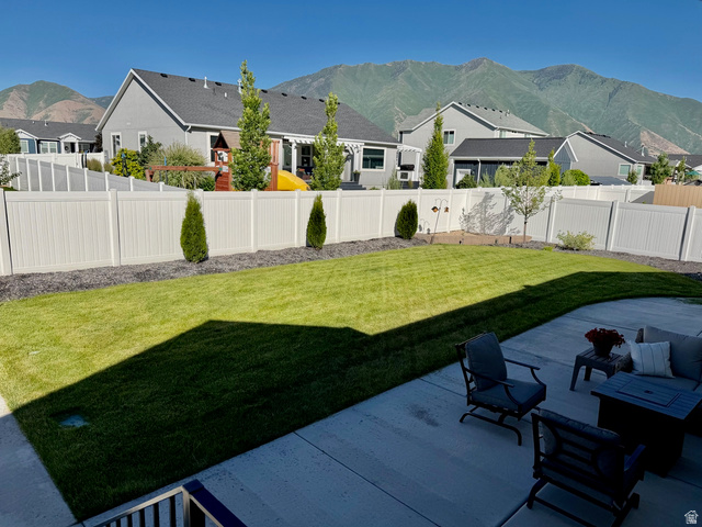 315 South Sherman Street Mapleton, UT 84664 - Photo 28 of 30 Expansive backyard featuring a spacious concrete patio, manicured lawn, full vinyl fencing, and distant mountain scenery