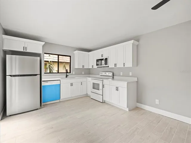 a kitchen with a refrigerator sink stove and microwave