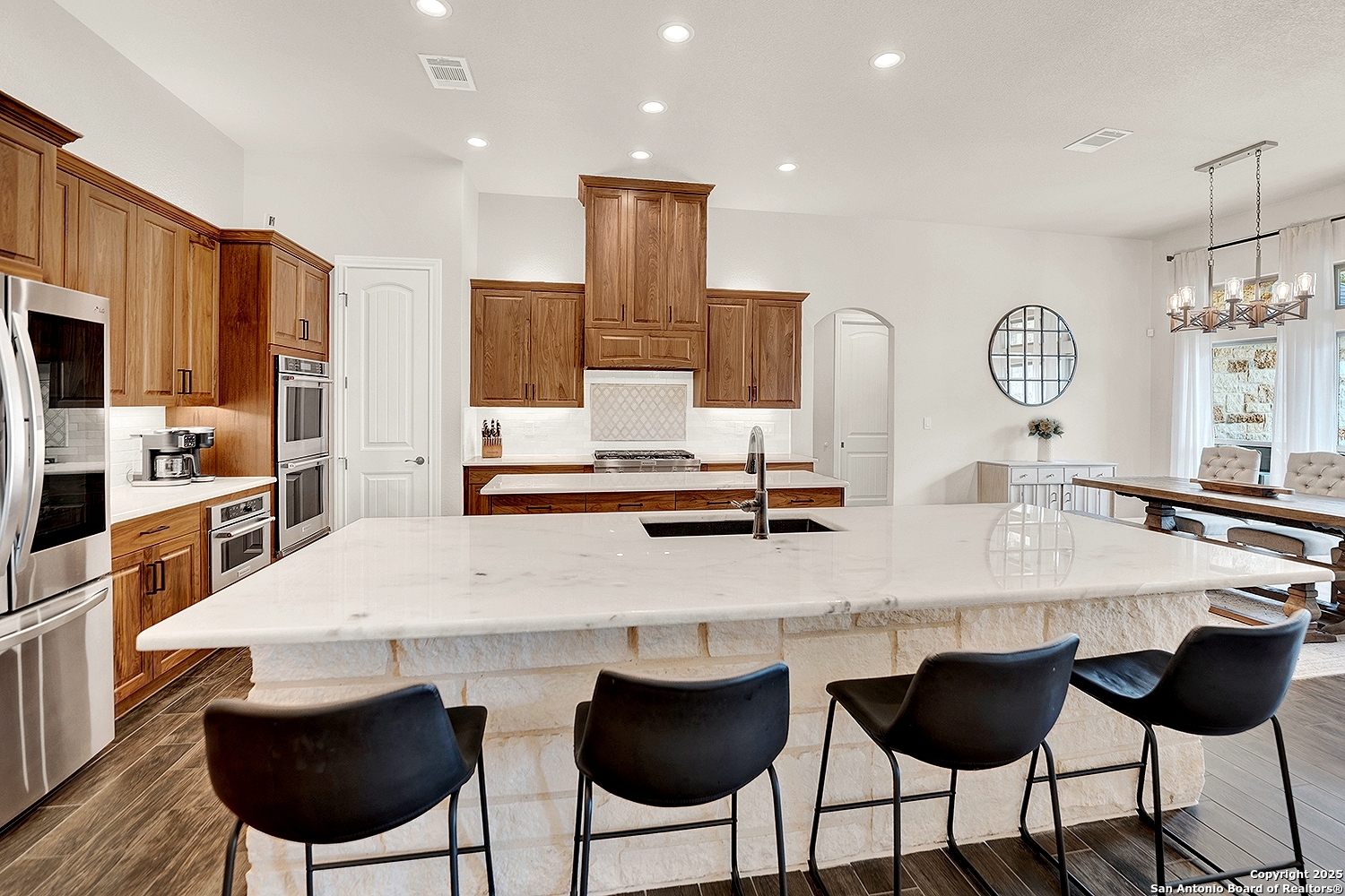 173 Hidden Pond Adkins, TX 78101 - Photo 11 of 40 a kitchen with stainless steel appliances granite countertop a table chairs and a refrigerator