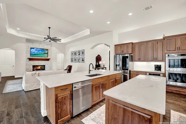 a large kitchen with sink a refrigerator and chairs