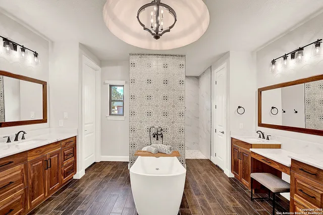 a room with wooden floors a sink and a mirror