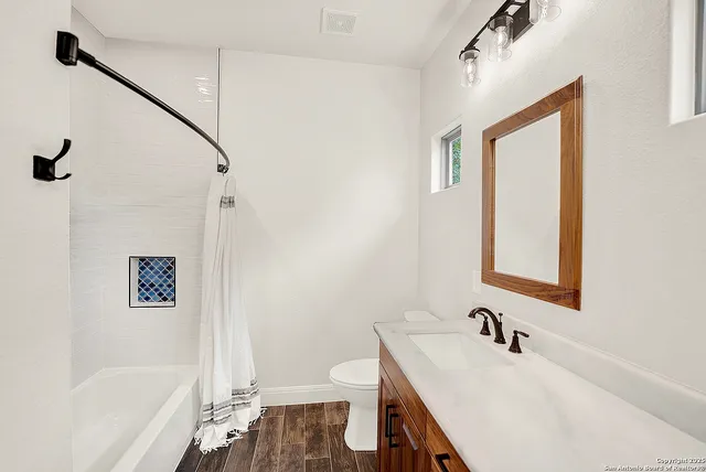 a bathroom with a sink a toilet and shower