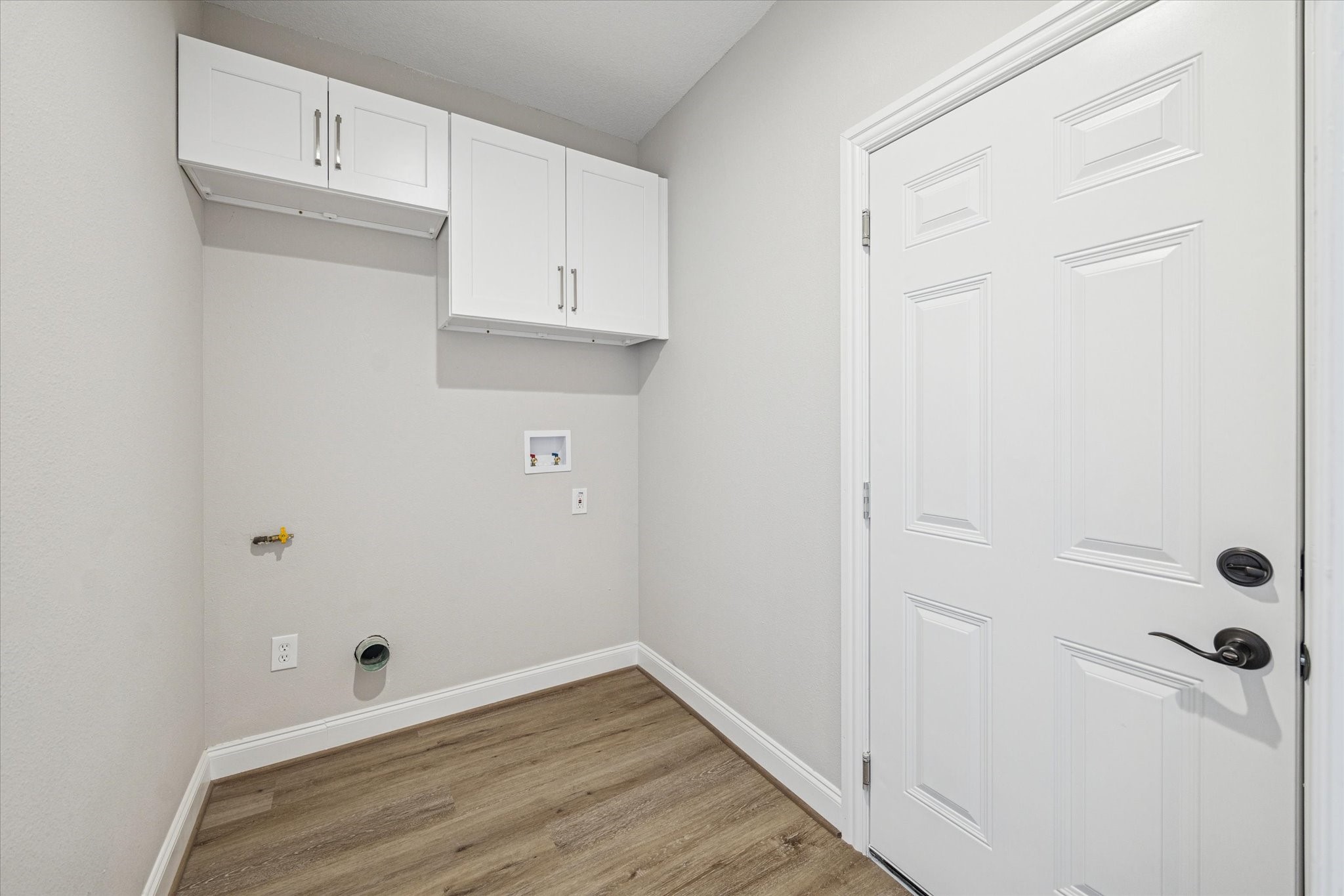 5437 Edgewater Court Willis, TX 77318 - Photo 26 of 29 a view of a kitchen with white cabinets and wooden floor