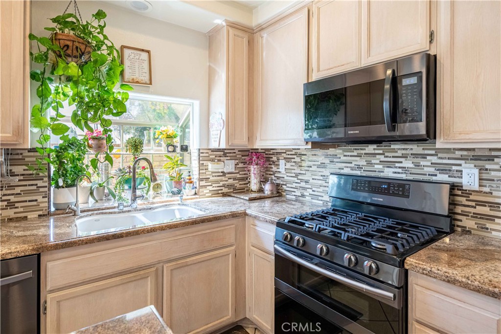 985 Brandon Avenue Simi Valley, CA 93065 - Photo 16 of 48 a kitchen with stainless steel appliances a stove a sink and a microwave