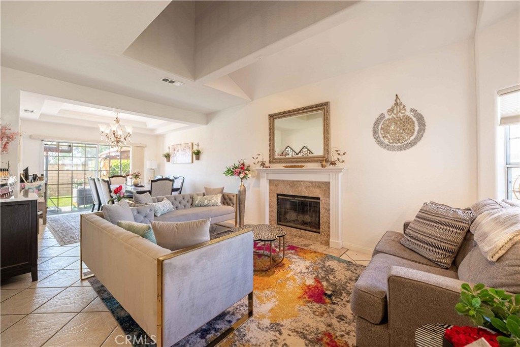 985 Brandon Avenue Simi Valley, CA 93065 - Photo 4 of 48 a living room with furniture a fireplace and a floor to ceiling window