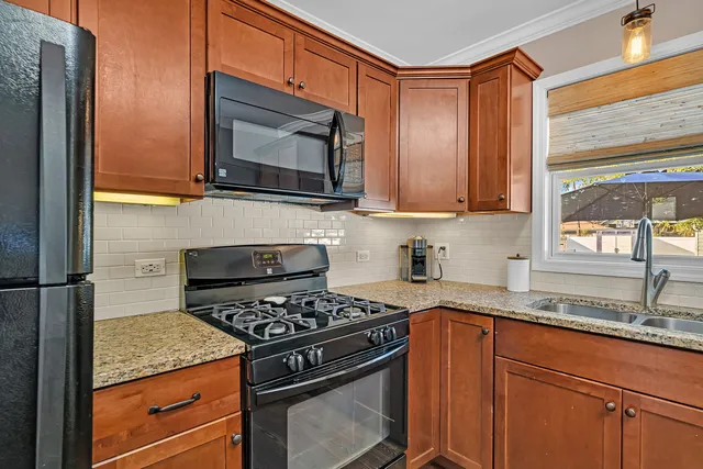 a kitchen with granite countertop a stove and a microwave