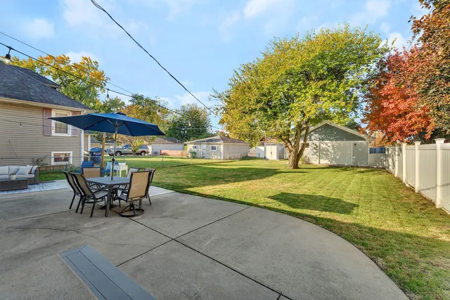 a view of a house with backyard and sitting area