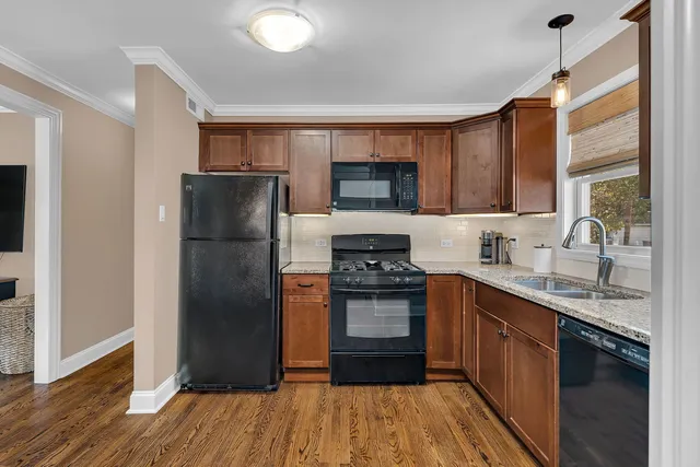 a kitchen with granite countertop a refrigerator stove top oven and sink