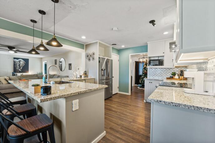 3008 68th Street Lubbock, TX 79413 - Photo 5 of 12 a kitchen with kitchen island a counter top space a sink stainless steel appliances and cabinets