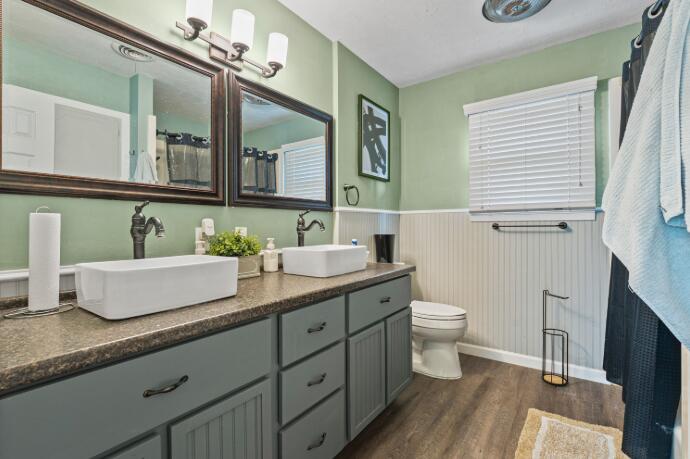 3008 68th Street Lubbock, TX 79413 - Photo 9 of 12 a bathroom with a granite countertop toilet sink and mirror