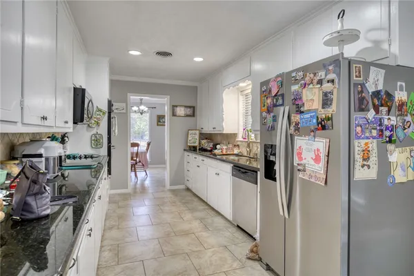 a kitchen with stainless steel appliances granite countertop a refrigerator and a sink