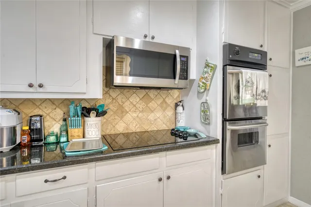 a kitchen with stainless steel appliances granite countertop white cabinets and a granite counter tops