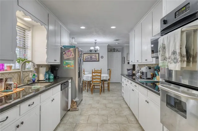 a kitchen with granite countertop a sink stainless steel appliances and cabinets