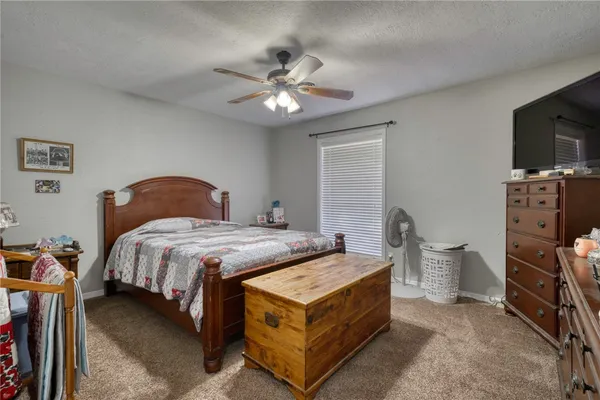 a bedroom with a bed and a flat tv screen on the dresser