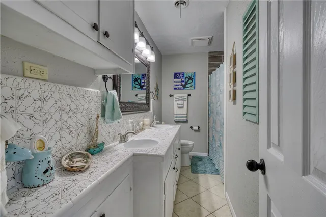 a bathroom with a granite countertop sink a toilet and shower