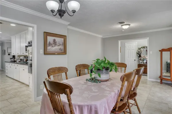 a view of a dining room with furniture and chandelier