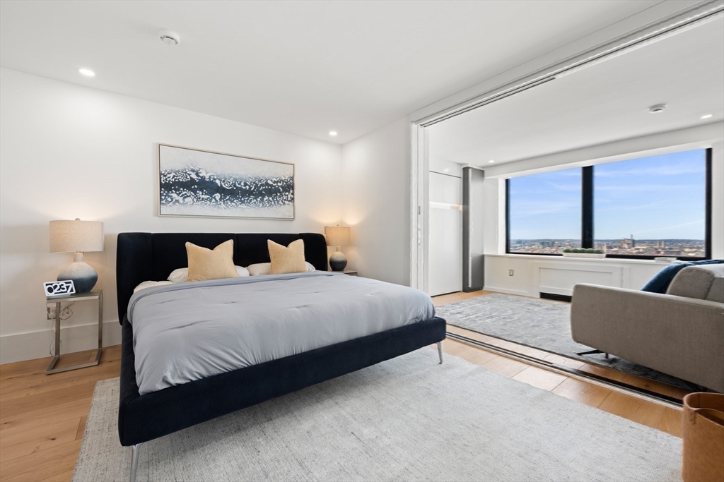 85 East India Row, Unit PHAB Boston, MA 02110 - Photo 31 of 42 a bedroom with a large bed and a couch