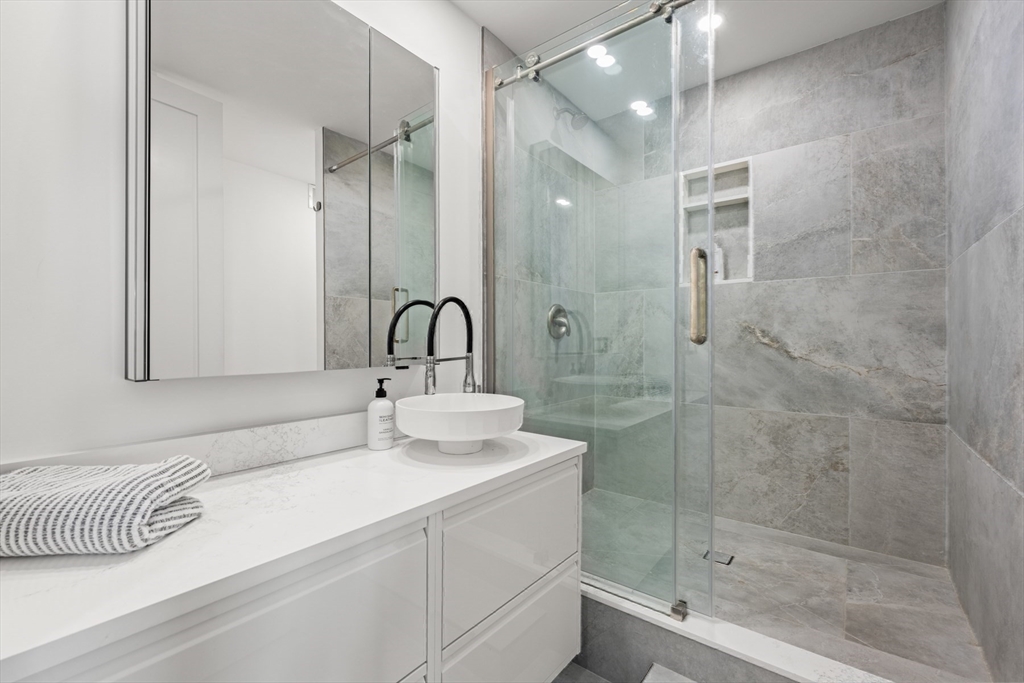 85 East India Row, Unit PHAB Boston, MA 02110 - Photo 33 of 42 a bathroom with a sink a shower and a mirror