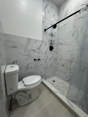 a bathroom with a toilet and a shower