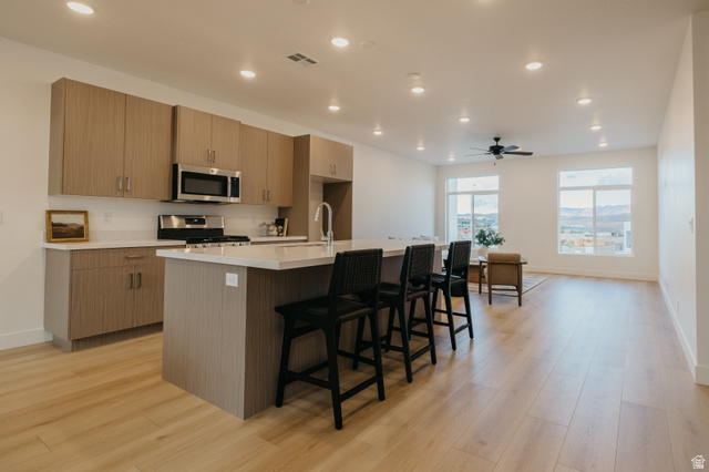 2759 Becco Trail, Unit 16 St. George, UT 84770 - Photo 4 of 42 Kitchen with a center island with sink, a breakfast bar area, recessed lighting, modern cabinets, and appliances with stainless steel finishes