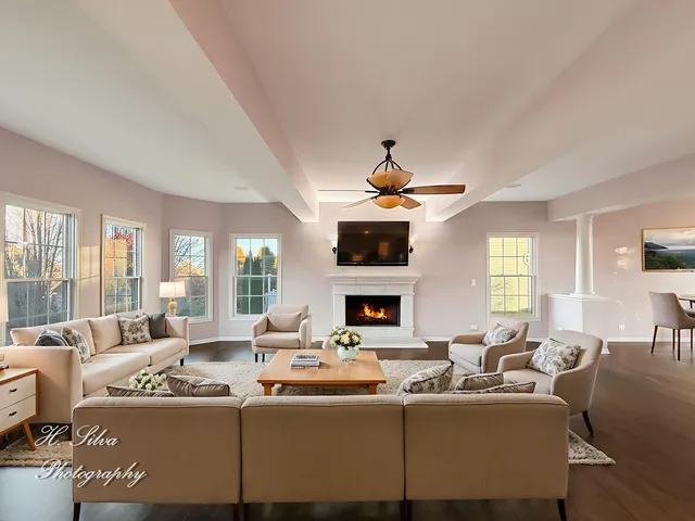 a living room with fireplace furniture and a large window