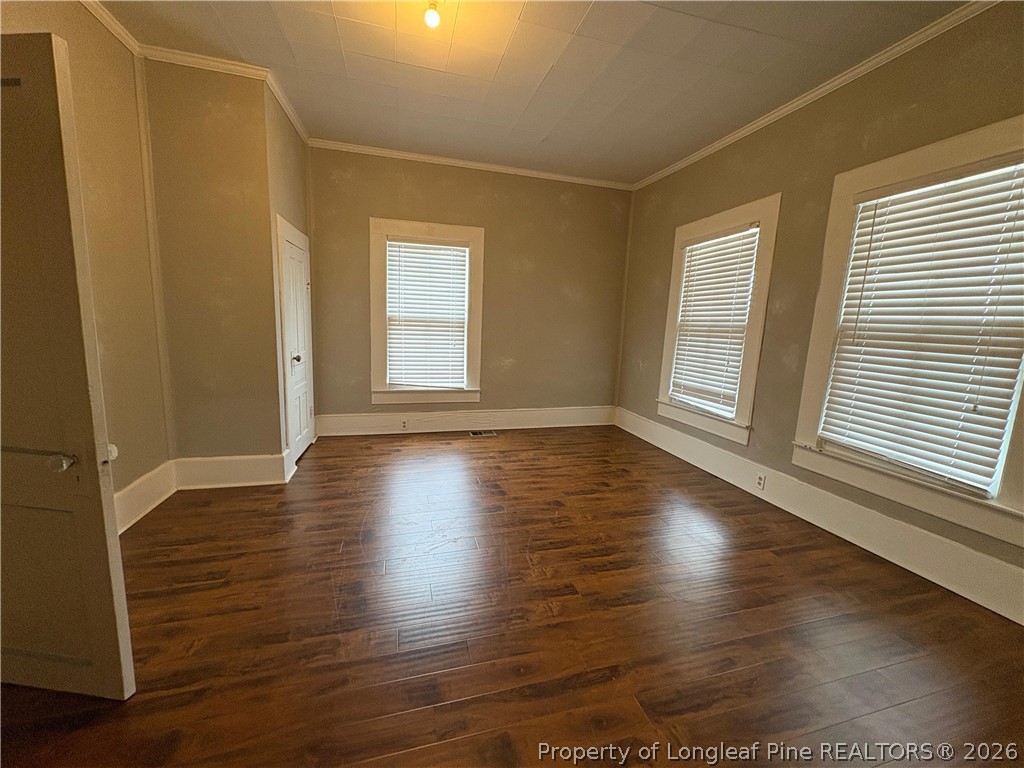 3174 Lindsay Road Raeford, NC 28376 - Photo 8 of 28 an empty room with wooden floor and windows with curtains