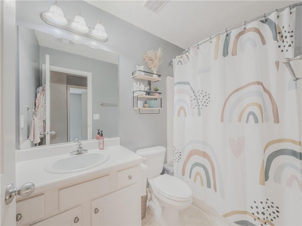 3100 Oak Ridge Lane Loganville, GA 30052 - Photo 28 of 43 a bathroom with a granite countertop sink a toilet and a mirror