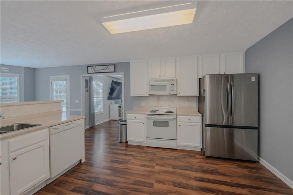 3100 Oak Ridge Lane Loganville, GA 30052 - Photo 10 of 43 a kitchen with white cabinets and stainless steel appliances