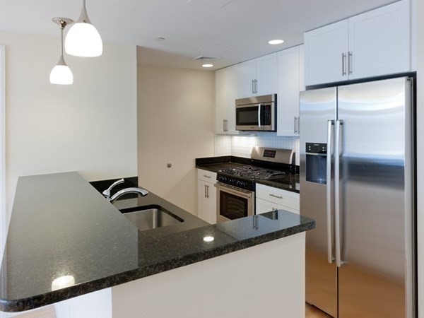 a kitchen with stainless steel appliances granite countertop a sink a stove and a refrigerator