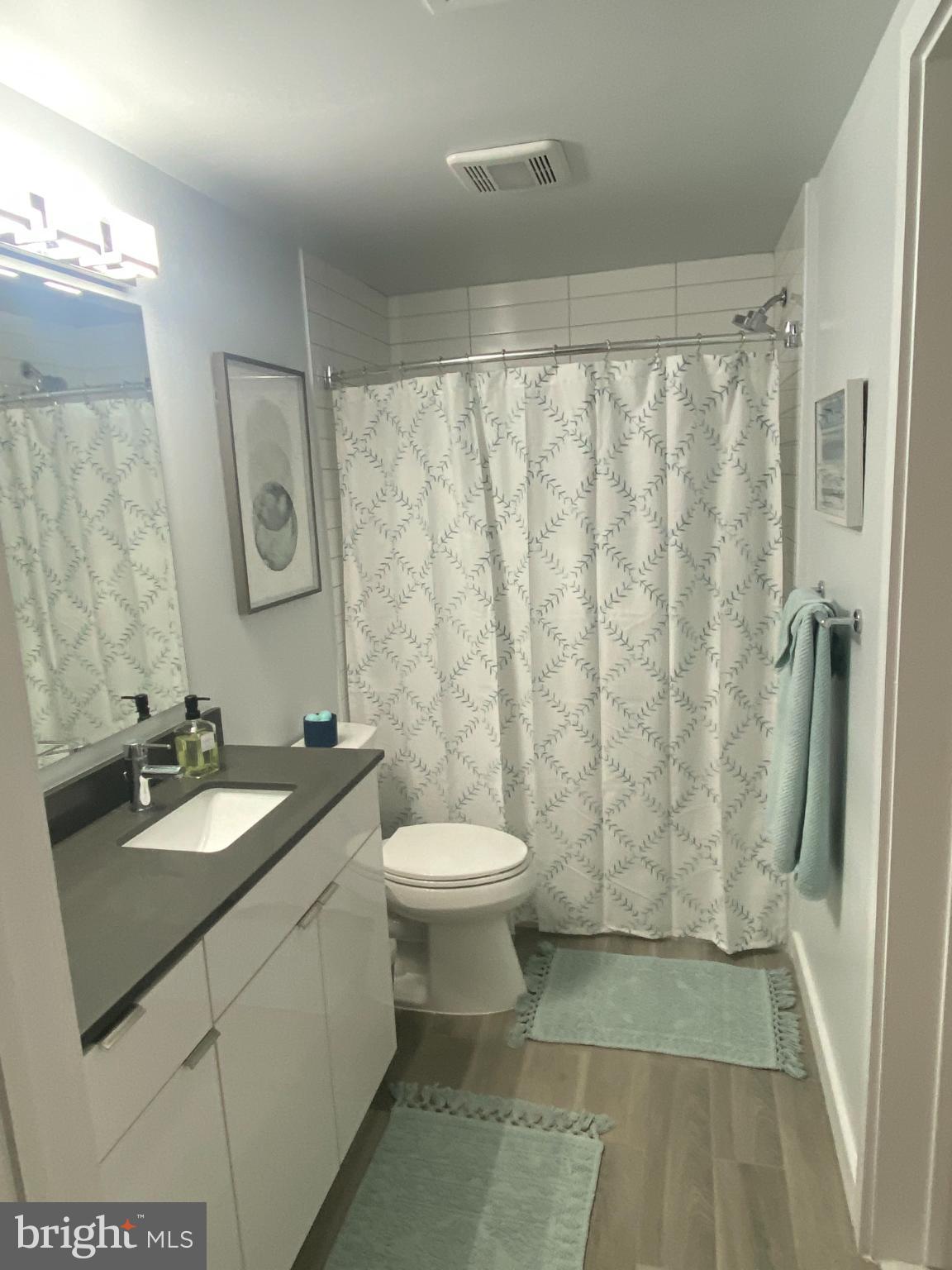 700 Roeder Road, Unit 405 Silver Spring, MD 20910 - Photo 16 of 18 a bathroom with a granite countertop sink toilet and shower