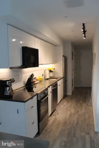a kitchen with stainless steel appliances granite countertop a sink and a stove