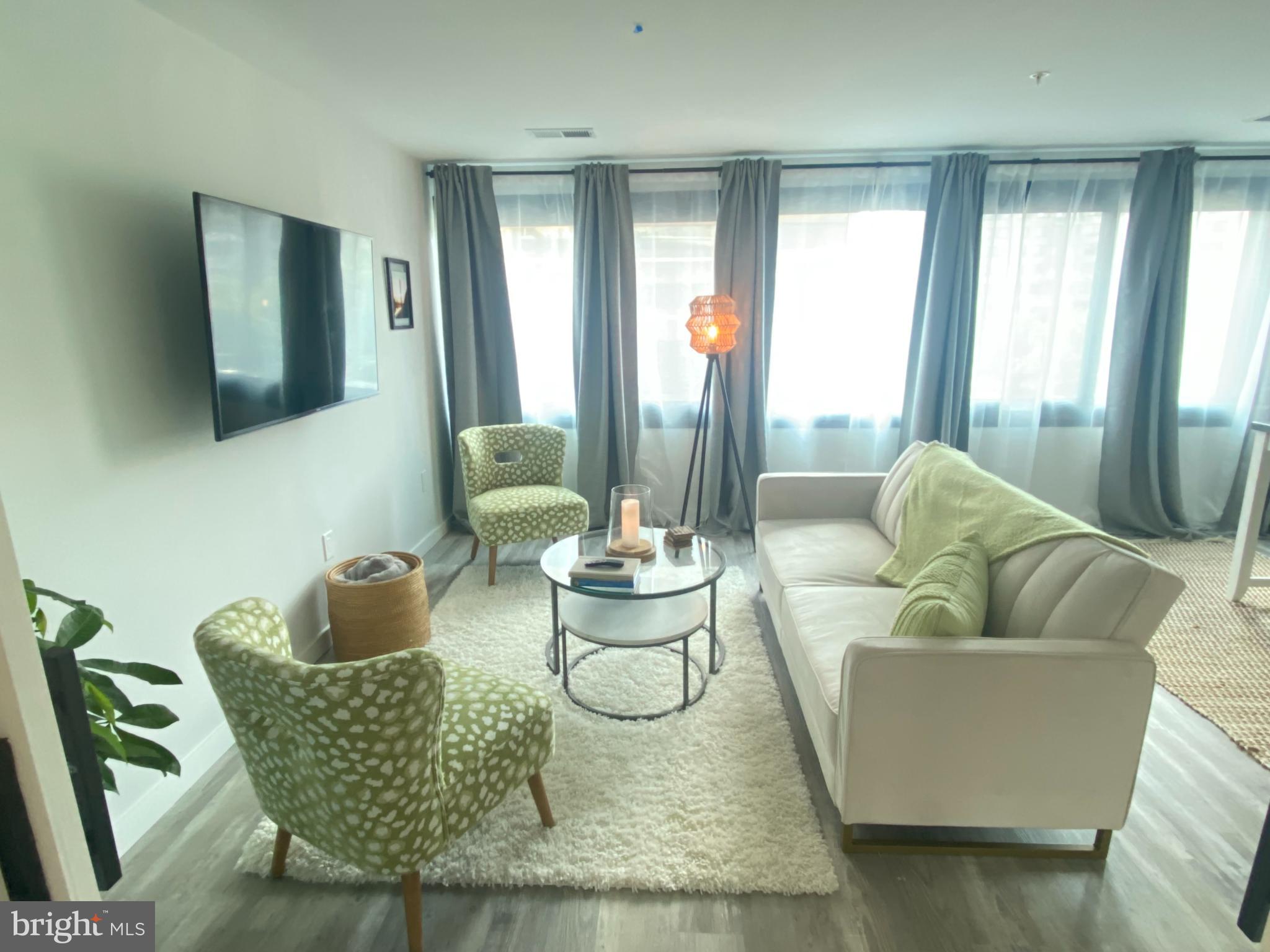 700 Roeder Road, Unit 405 Silver Spring, MD 20910 - Photo 6 of 18 a living room with furniture and a large window