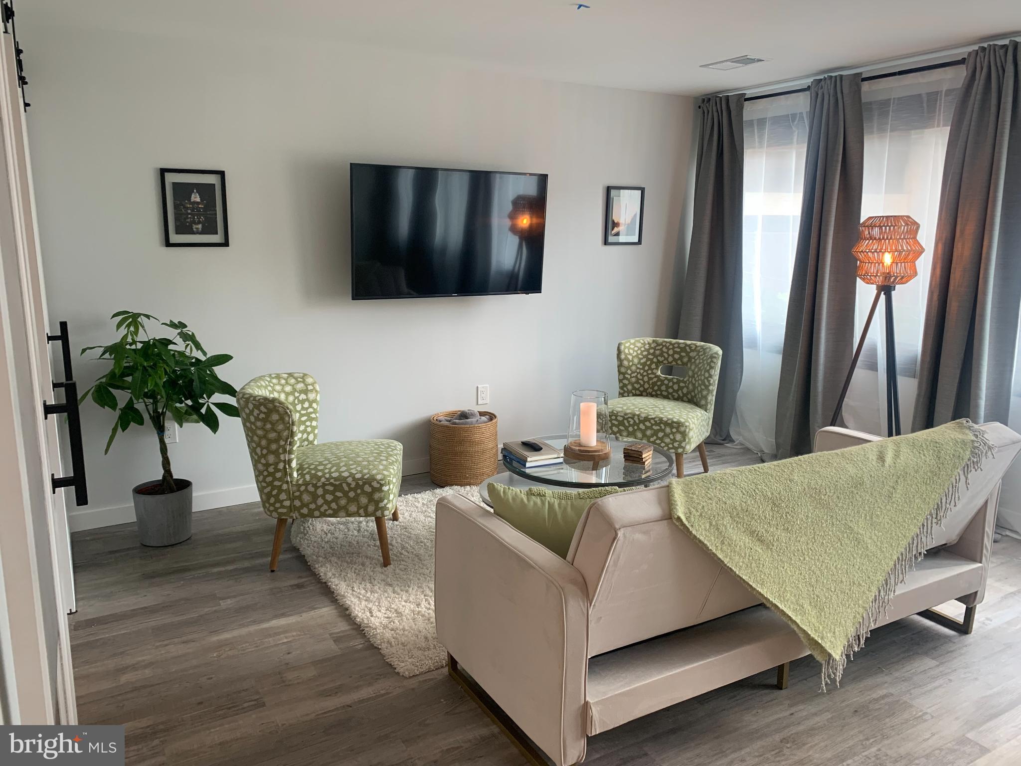 700 Roeder Road, Unit 405 Silver Spring, MD 20910 - Photo 8 of 18 a living room with furniture and a flat screen tv